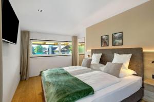 a bedroom with a large bed with a large window at Premium App Hofer Silena in Villabassa