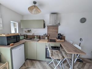 a kitchen with a wooden table and chairs at Jo And Manu's Barn in Falaise