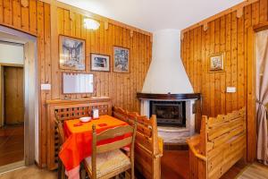 una sala da pranzo con tavolo e camino di Albergo Trieste - Lorenzago a Lorenzago