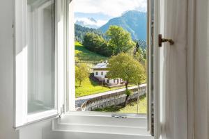 una finestra aperta con vista su una casa di Albergo Trieste - Lorenzago a Lorenzago