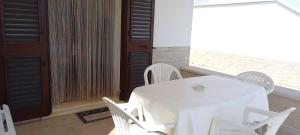 a white table and chairs in a room with a window at Villetta Lucy in Salve +18 photos