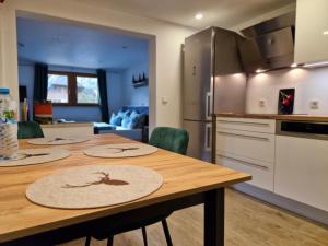 a kitchen with a wooden table with chairs in a kitchen at Ferienwohnung Vordere Halde in Elzach