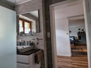 a bathroom with a sink and a mirror at Ferienwohnung Vordere Halde in Elzach +28 photos
