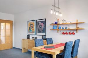 a dining room with a wooden table and blue chairs at Ferienwohnung Tannenblick 2-4 in Oberhof