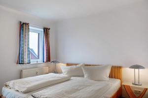 a bedroom with a bed with white sheets and a window at Ferienwohnung Tannenblick 2-4 in Oberhof