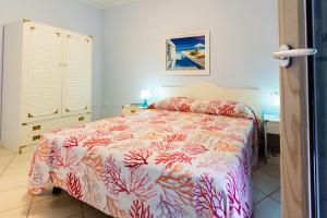 a bedroom with a bed with a coral bedspread at La Pergola al Cavo 5 in Cavo +33 photos
