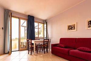 a living room with a red couch and a table at La Pergola al Cavo 5 in Cavo