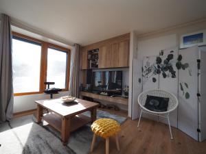 a living room with a table and a refrigerator at Appartement - Vue montagne in Cazeaux-de-Larboust