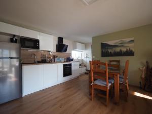a kitchen with a table and chairs in a room at Appartement - Vue montagne in Cazeaux-de-Larboust