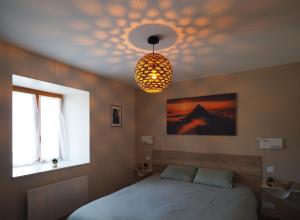 a bedroom with a bed and a chandelier at Appartement - Vue montagne in Cazeaux-de-Larboust