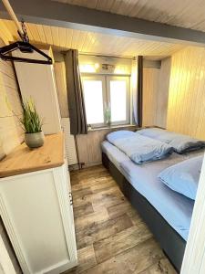 a small bedroom with a bed and a window at Leonies Emsblick in Walchum