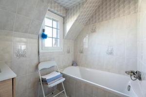 a bathroom with a tub and a sink and a window at Chambre d'hote Reine in Cancale +13 photos