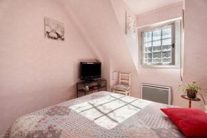 a bedroom with a bed and a tv and a window at Chambre d'hote Reine in Cancale