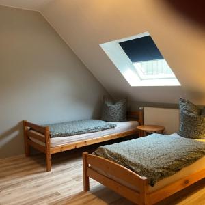 a attic room with two beds and a skylight at Ferienhof Anke Thiede in Lehe