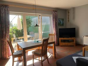 a living room with a table and chairs and a television at Ferienhof Anke Thiede in Lehe