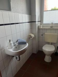 a bathroom with a toilet and a sink at Ferienhof Anke Thiede in Lehe +12 photos