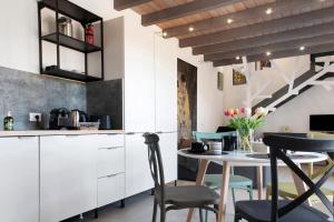 a kitchen with white cabinets and a table with chairs at Residenza La Fonte Dependance in Laveno-Mombello