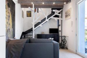 a living room with a blue couch and a staircase at Residenza La Fonte Dependance in Laveno-Mombello