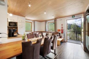 a dining room with a long table and chairs at Joshof Bergblick in Moso