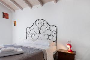 a white bedroom with a bed with a metal headboard at Residenza La Fonte Dependance in Laveno-Mombello