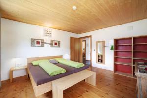 a bedroom with a bed with green pillows on it at Joshof Bergblick in Moso