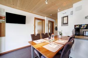 a dining room with a wooden table and chairs at Joshof Bergblick in Moso