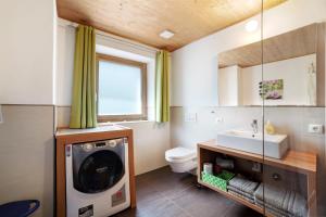 a bathroom with a washing machine and a sink at Joshof Bergblick in Moso +23 photos