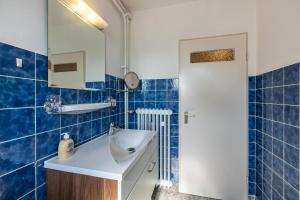 a blue tiled bathroom with a sink and a mirror at Aparthotel am Stadtpark in Bad Sachsa +59 photos