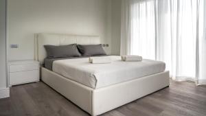 a white bed with two pillows on it in a bedroom at Villa Sirmione Front Lake in Sirmione +30 photos