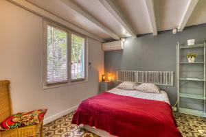 a bedroom with a red bed and a window at Villa - Oasis centre charme in Montpellier