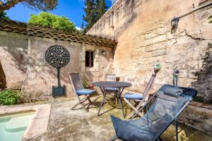 a patio with a table and chairs next to a pool at Villa - Oasis centre charme in Montpellier