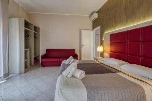 a bedroom with a large bed and a red couch at Sant'Oronzo House in Lecce