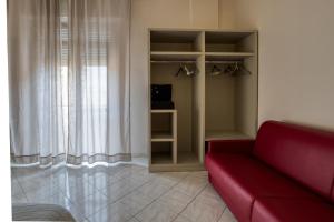 a living room with a red couch next to a window at Sant'Oronzo House in Lecce