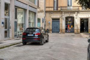 a small black car parked on a city street at Sant'Oronzo House in Lecce