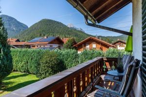 a balcony with chairs and mountains in the background at Ferienwohnungen St Christoph in Mittenwald