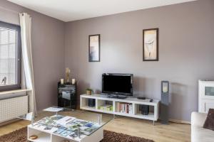 a living room with a tv and a glass table at Ferienwohnung Sonnenschein in Bad Hersfeld