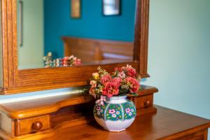 a vase with flowers sitting on a table in front of a mirror at Matxingonea 1 in Urdax