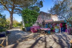 a backyard with a table and chairs and a store at Le Mazet Du Maréchal Ferrant in Maguelonne-la-Sauvage