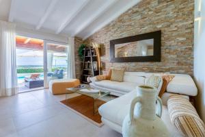 a living room with a white couch and a brick wall at Villa Flora Sea View in Cuile Pazzoni