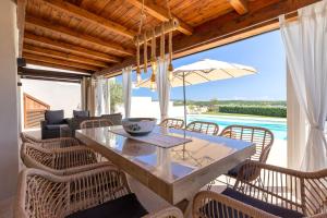 a dining room with a table and chairs and a view of the ocean at Villa Flora Sea View in Cuile Pazzoni
