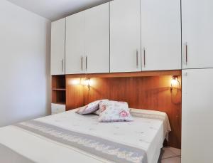 a bedroom with white cabinets and a bed with a pillow at Appartamento Tramonto in Capoliveri