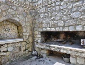 a stone wall with a bench in front of a fireplace at Appartamento Tramonto in Capoliveri