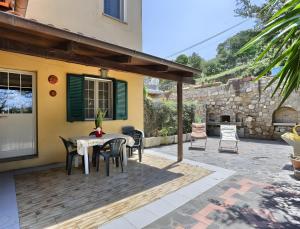 a patio with a table and chairs and a stone wall at Appartamento Tramonto in Capoliveri