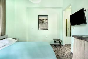 a hotel room with a bed and a flat screen tv at Old Boat double studio 1 in Nikiana