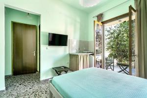 a bedroom with a bed and a tv on the wall at Old Boat double studio 1 in Nikiana