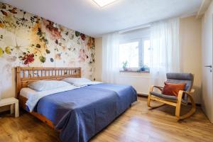 a bedroom with a blue bed and a chair at s'Lähmes auf der Schwend in Kappelrodeck
