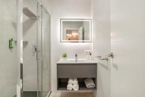a white bathroom with a sink and a shower at Apartamentos Bellamar in Barbate +111 photos