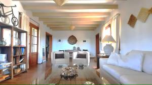 a living room with a white couch and a table at Charming villa by the sea in Llucmajor