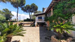 a house with a balcony and palm trees at Charming villa by the sea in Llucmajor