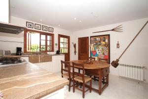 a kitchen with a wooden table and chairs in it at Charming villa by the sea in Llucmajor